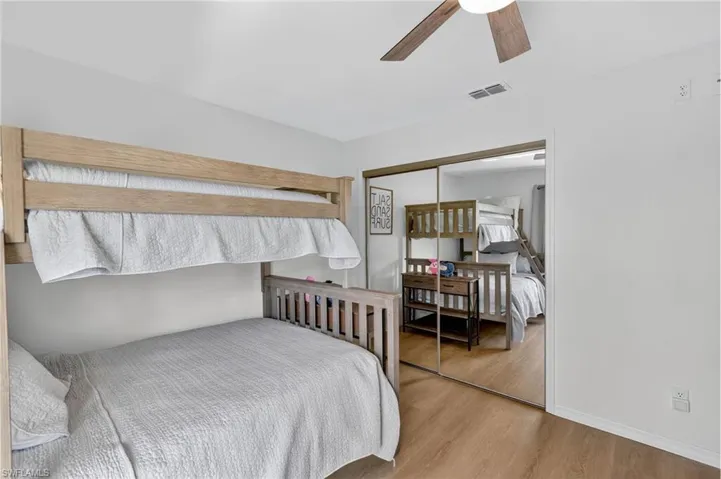 Bedroom featuring light wood-type flooring, a closet, and a ceiling fan