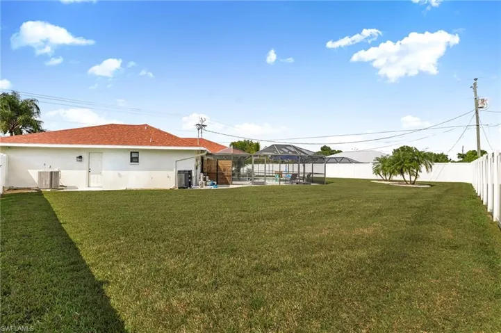 Fenced backyard with a pool, a patio, and glass enclosure