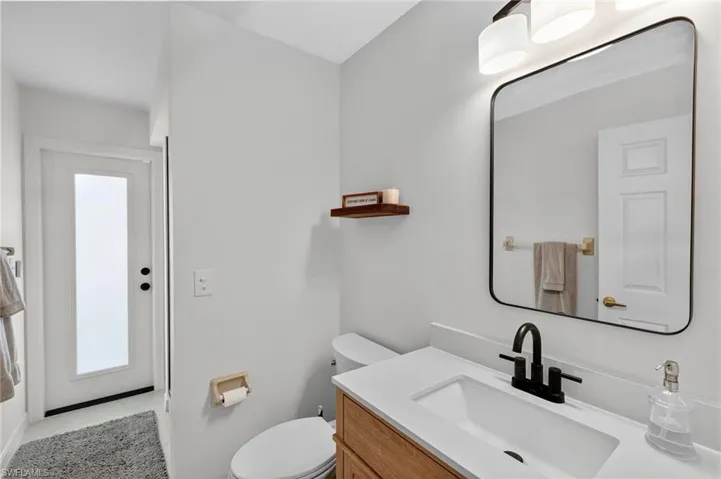 Bathroom with vanity, light tile patterned flooring, and healthy amount of natural light