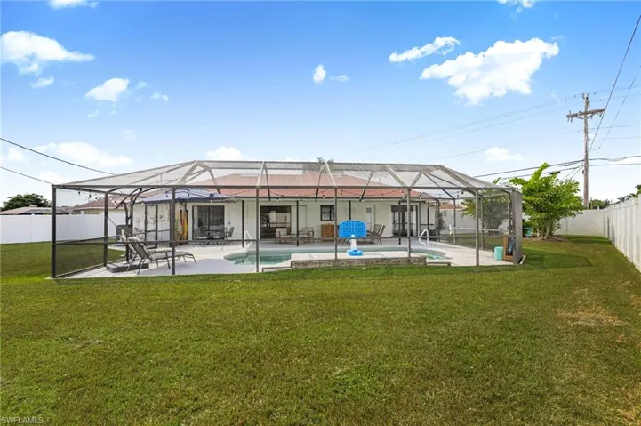 Back of house featuring a fenced backyard, a sunroom, glass enclosure, and a patio