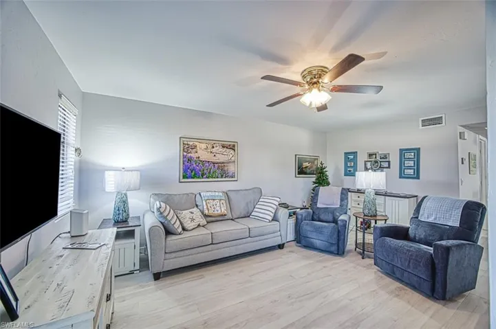 Living room with light hardwood / wood-style flooring and ceiling fan