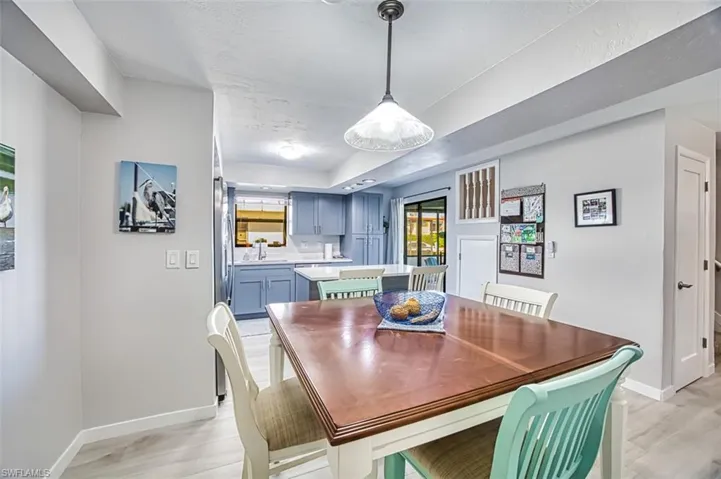 Dining area with light hardwood / wood-style floors and a tray ceiling