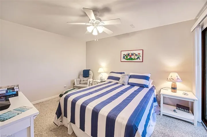 Carpeted bedroom featuring ceiling fan