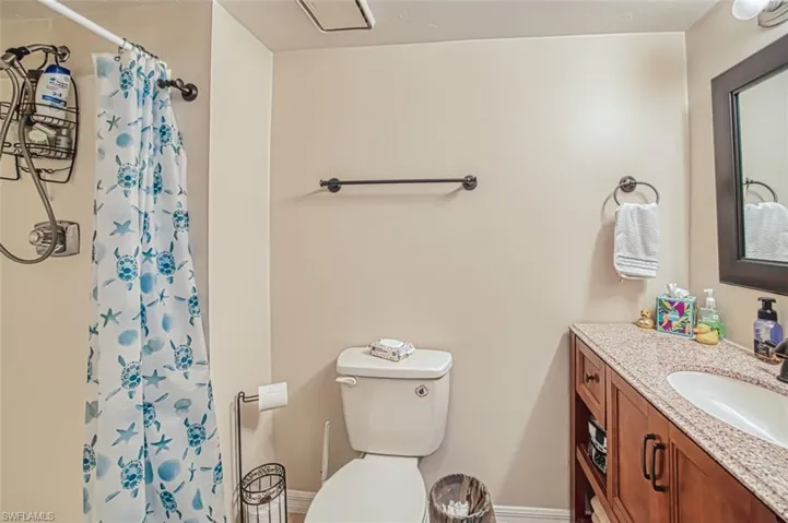 Bathroom with a shower with curtain, vanity, and toilet