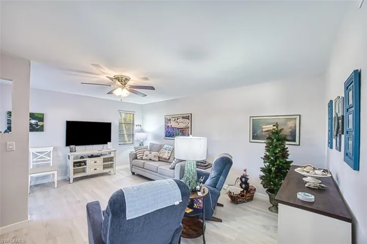 Living room with ceiling fan and light wood-type flooring