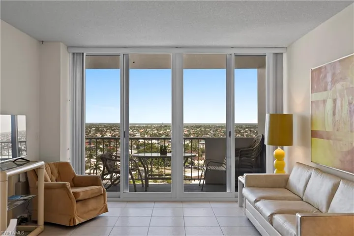 Living room featuring tile patterned flooring, a textured ceiling, and floor to ceiling windows