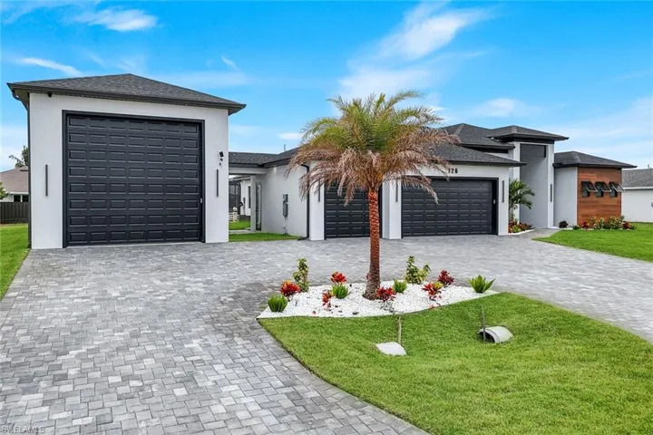 Prairie-style house with stucco siding, a garage, decorative driveway, and a front yard