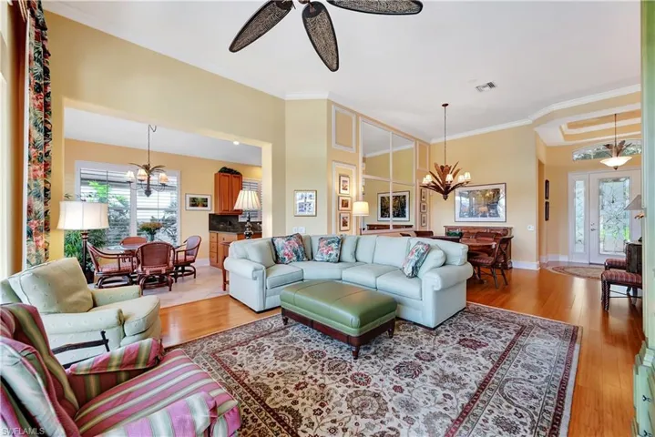 Living room featuring crown molding, a high ceiling, and bamboo flooring.