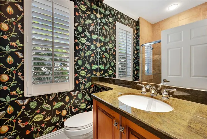 Bathroom with vanity, toilet, and a shower with glass shower door.