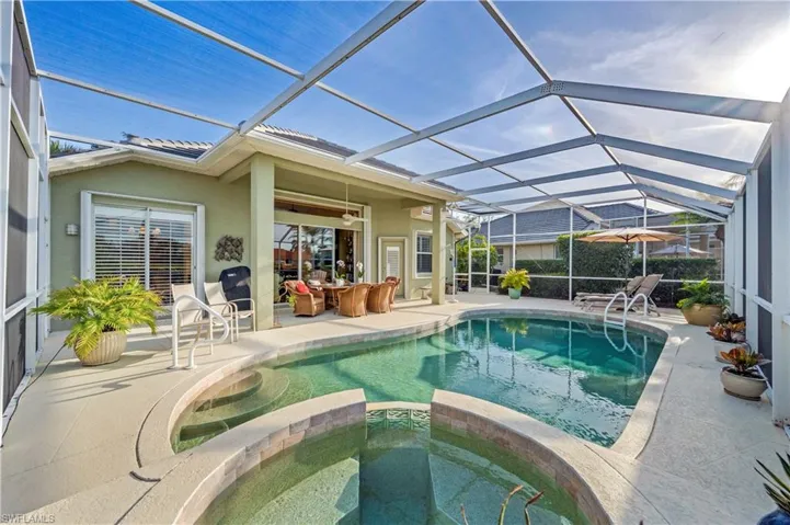 View of swimming pool with an in ground hot tub, spacious lanai and patio area.
