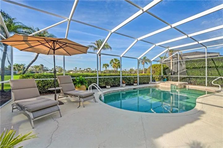 View of pool featuring a lanai and a patio area and overlooking the golf course.