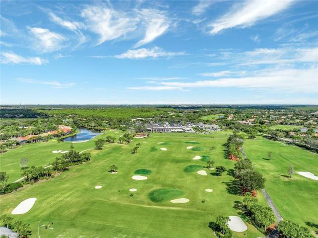 Double-sided driving range with expansive tees, target greens with bunkers, short game practice areas, and several putting greens.