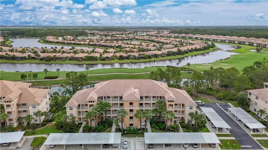Aerial view of residential area featuring a local golf course and a nearby body of water