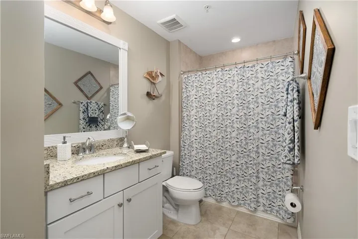 Bathroom with tile patterned flooring, vanity, and curtained shower