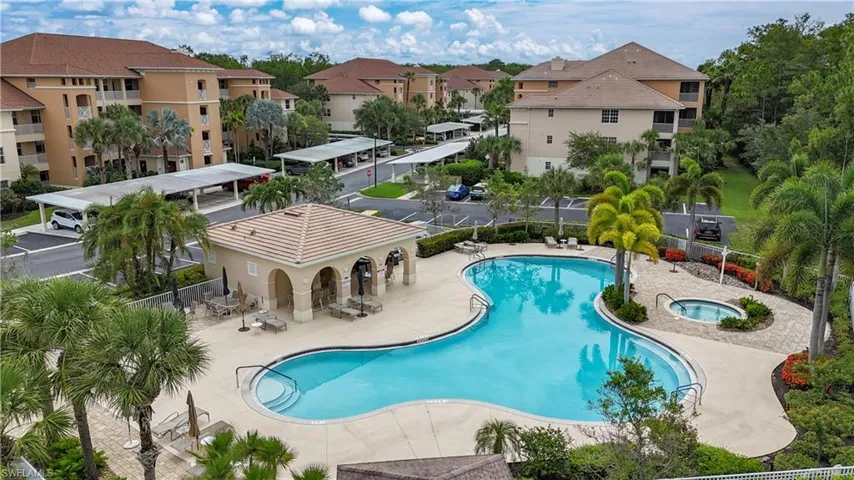 Community pool featuring a community hot tub, a patio area, and a residential view