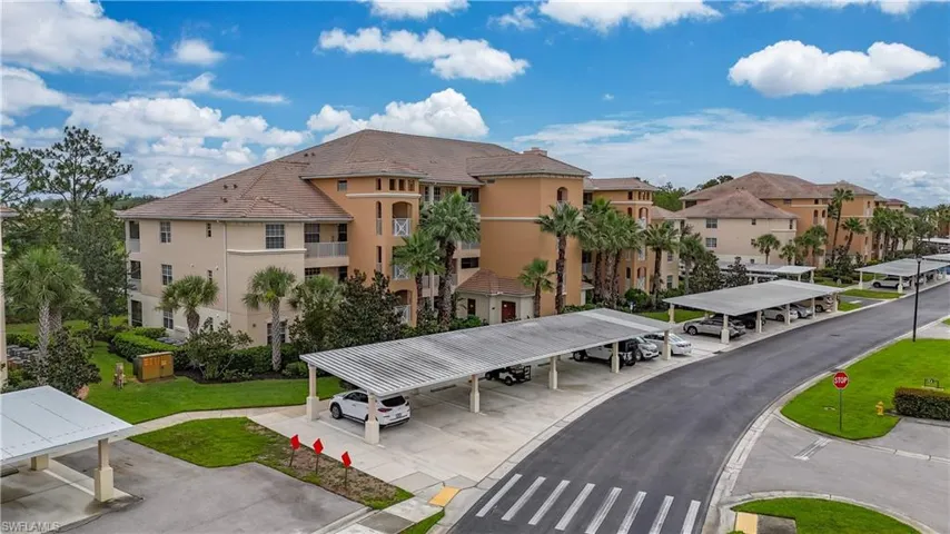 View of building exterior featuring covered parking and a residential view