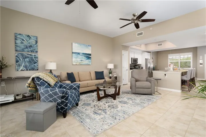 Living area with a ceiling fan and light tile patterned floors