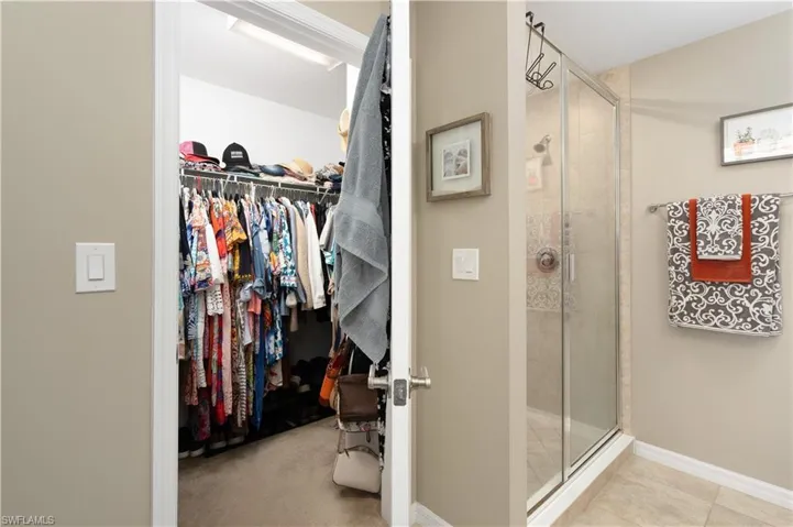 Bathroom with a stall shower and a spacious closet