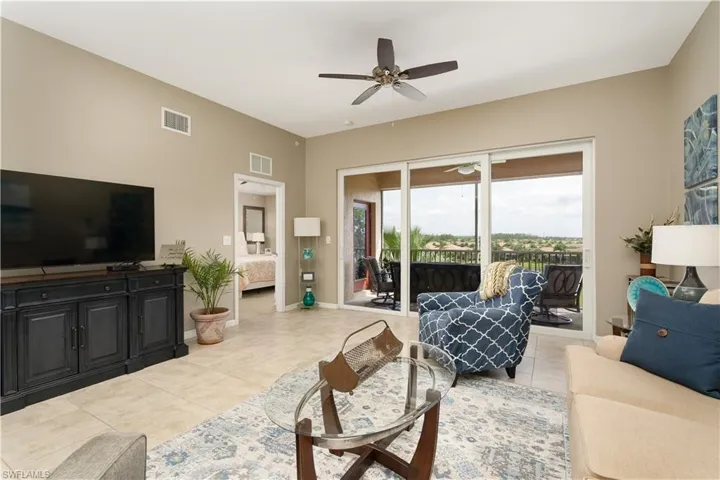 Living area with ceiling fan and light tile patterned floors