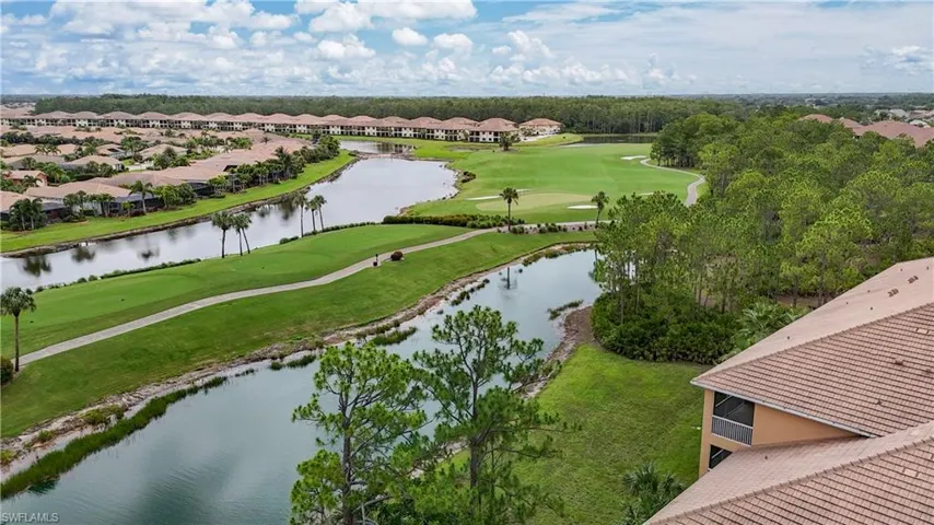 Aerial perspective of suburban area with a golf course and a nearby body of water
