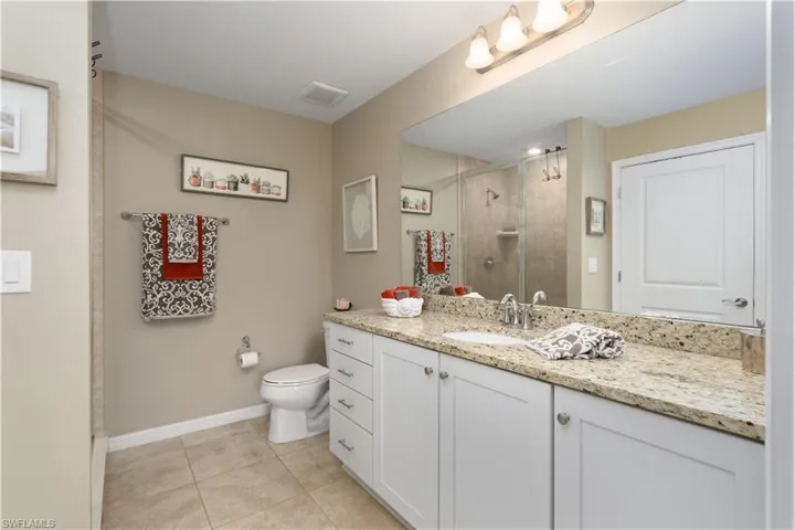 Full bath with vanity, a stall shower, and tile patterned floors