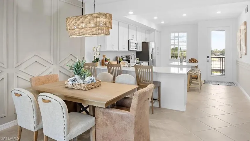 Dining area with light tile patterned floors, a chandelier, and recessed lighting