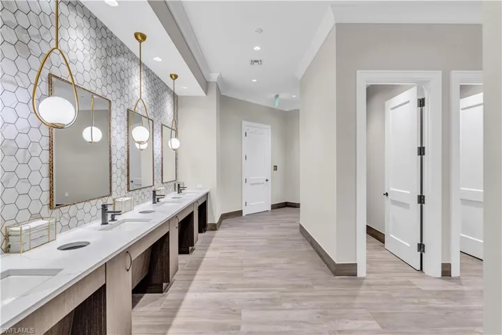 Bathroom with double vanity, recessed lighting, and crown molding