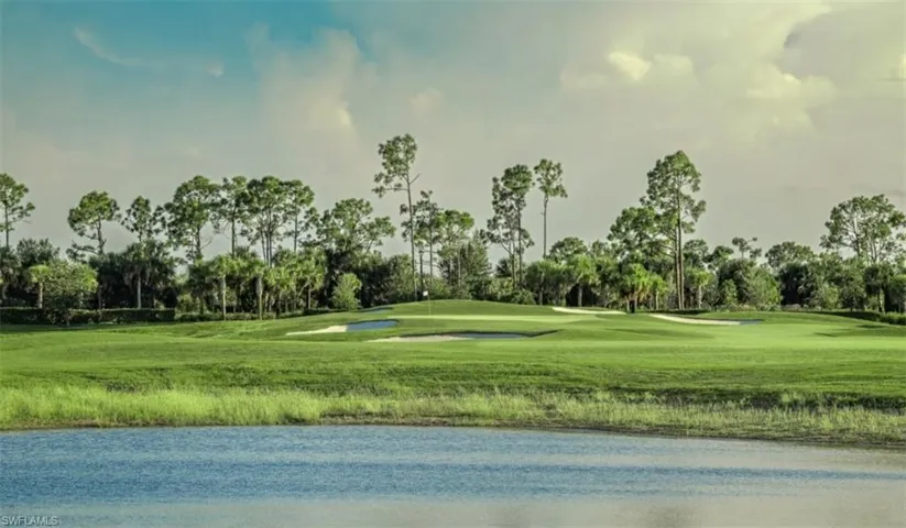 Surrounding community featuring view of golf course, view of wooded area, and a yard