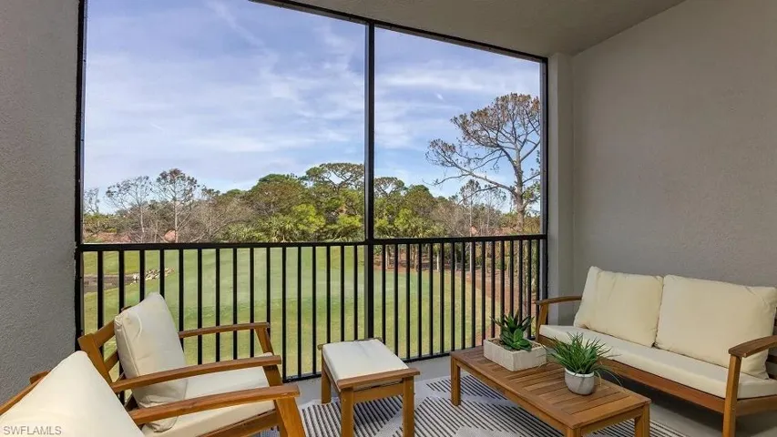 Sunroom / solarium featuring view of scattered trees