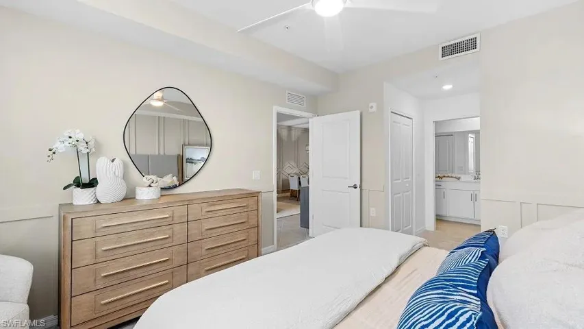 Bedroom featuring ensuite bath, a ceiling fan, and light colored carpet
