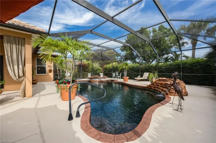 Integrated pool / hot tub featuring glass enclosure, a sunroom, and a patio area