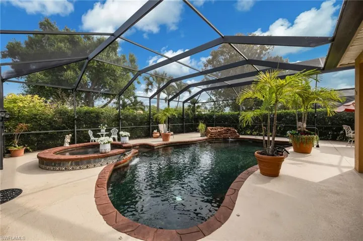 Integrated pool / hot tub featuring glass enclosure, a sunroom, and a patio area