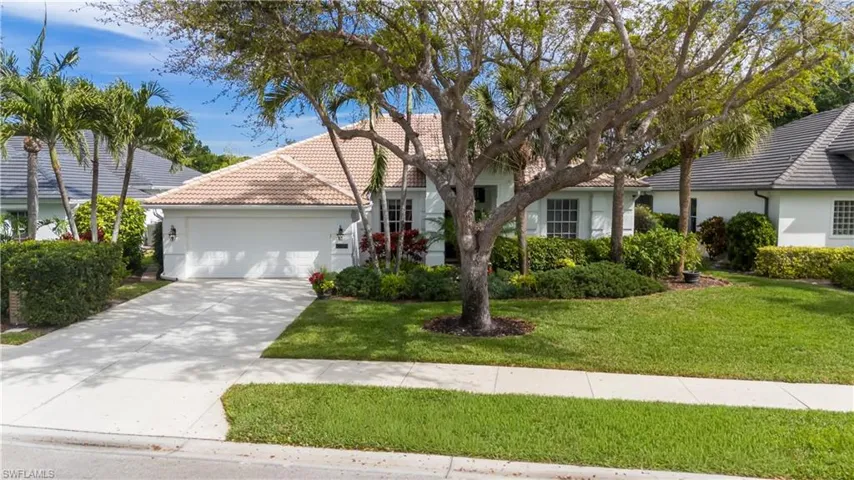 View of front of home with stucco siding, a tile roof, an attached garage, driveway, and a front lawn