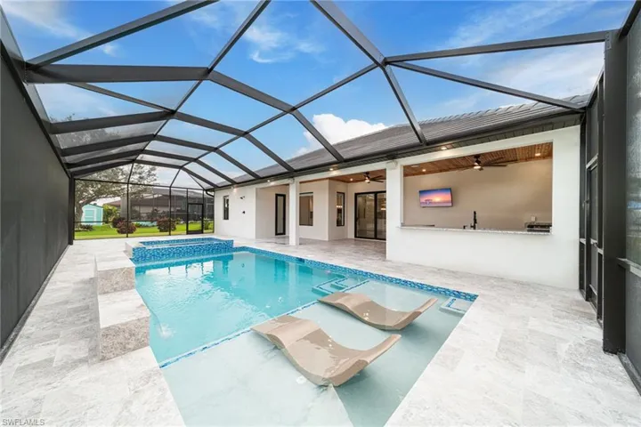 View of swimming pool with ceiling fan, a patio area, and a lanai