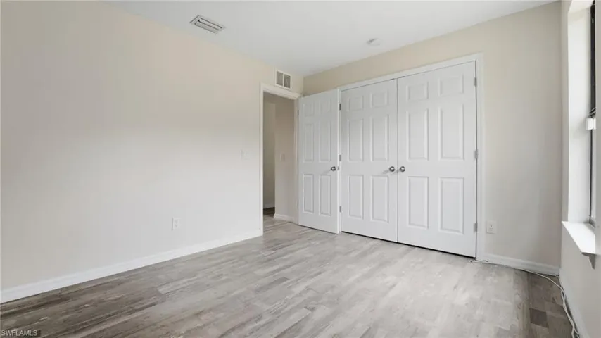Unfurnished bedroom with light wood finished floors and a closet