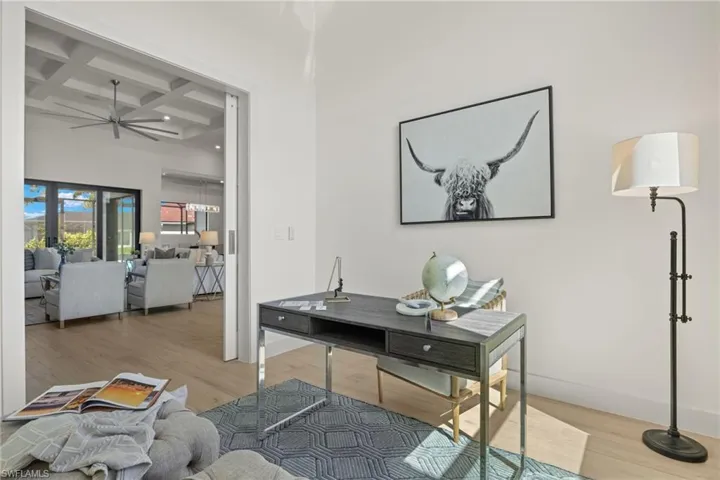 Office featuring ceiling fan, beamed ceiling, hardwood / wood-style flooring, and coffered ceiling