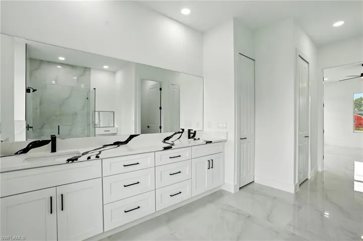 Bathroom featuring light marble finish flooring, a marble finish shower, recessed lighting, and ceiling fan