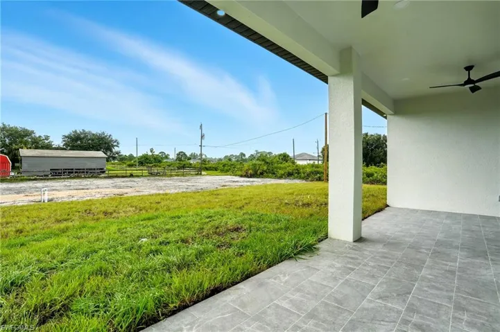 View of patio featuring ceiling fan and an outdoor structure