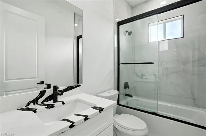 Bathroom featuring light marble finish floors, a marble finish shower, double vanity, a closet, and recessed lighting