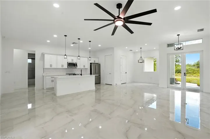 Unfurnished dining area with light marble finish flooring, french doors, and a chandelier