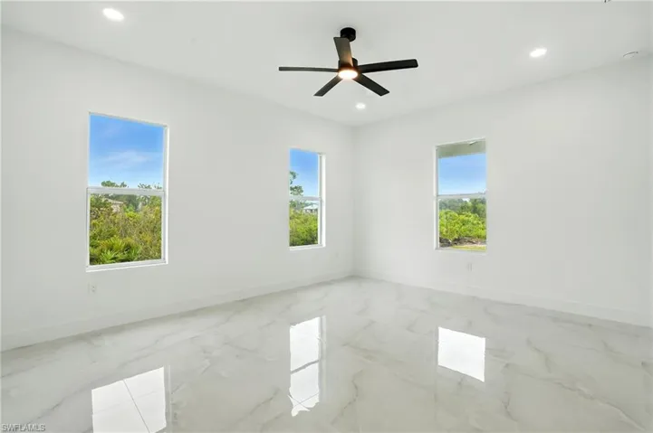 Kitchen with open floor plan, light marble finish flooring, white cabinetry, recessed lighting, and pendant lighting