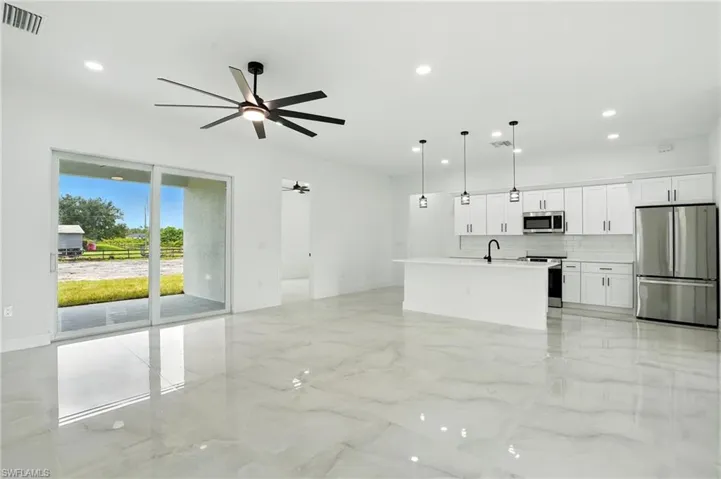Unfurnished living room featuring light marble finish flooring, recessed lighting, and ceiling fan
