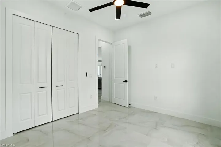Empty room featuring light marble finish flooring, a chandelier, and recessed lighting