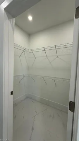 Spacious closet with light marble finish flooring