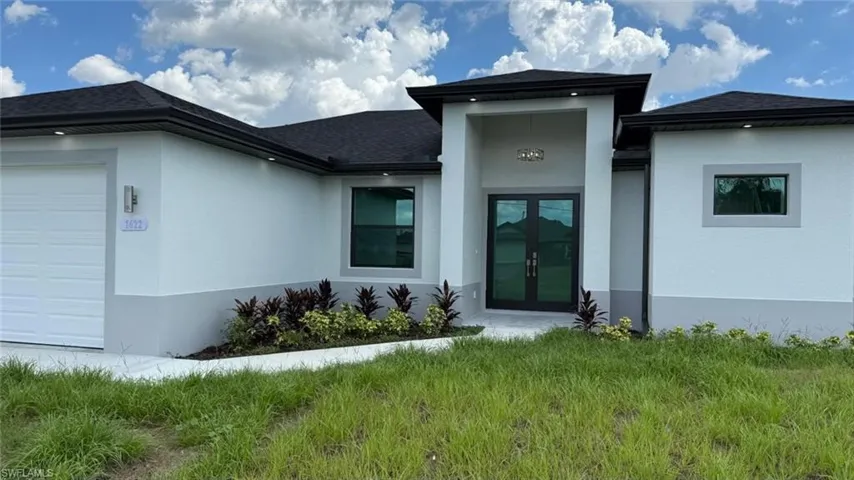 Entrance to property with an attached garage, stucco siding, a shingled roof, and french doors