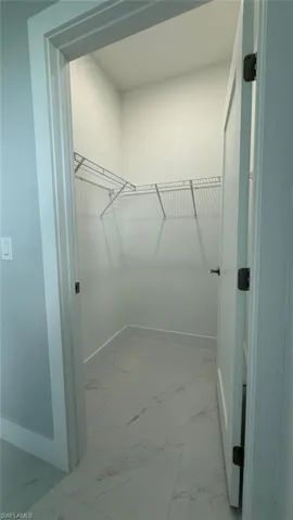 Spacious closet with light marble finish flooring
