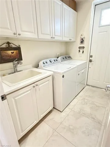 Washroom featuring cabinet space and independent washer and dryer
