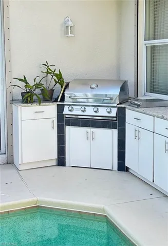 View of patio / terrace featuring an outdoor kitchen and an outdoor pool