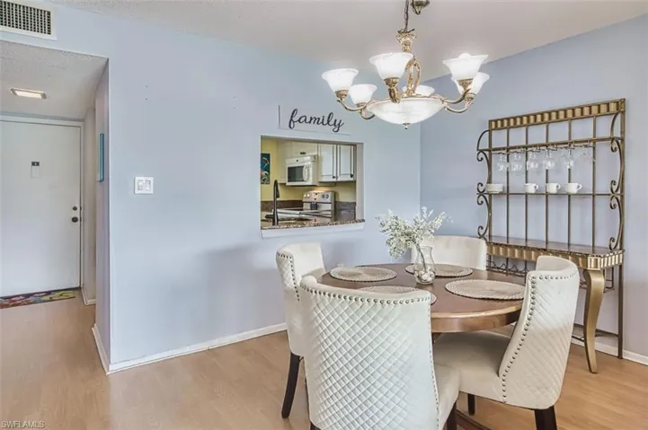 Dining room with hanging lights and light wood finished floors