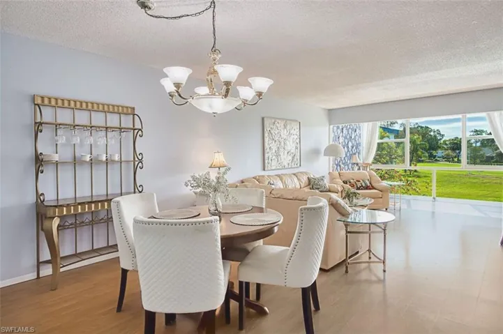 Dining area featuring a textured ceiling, suspended lighting, and wood finished floors